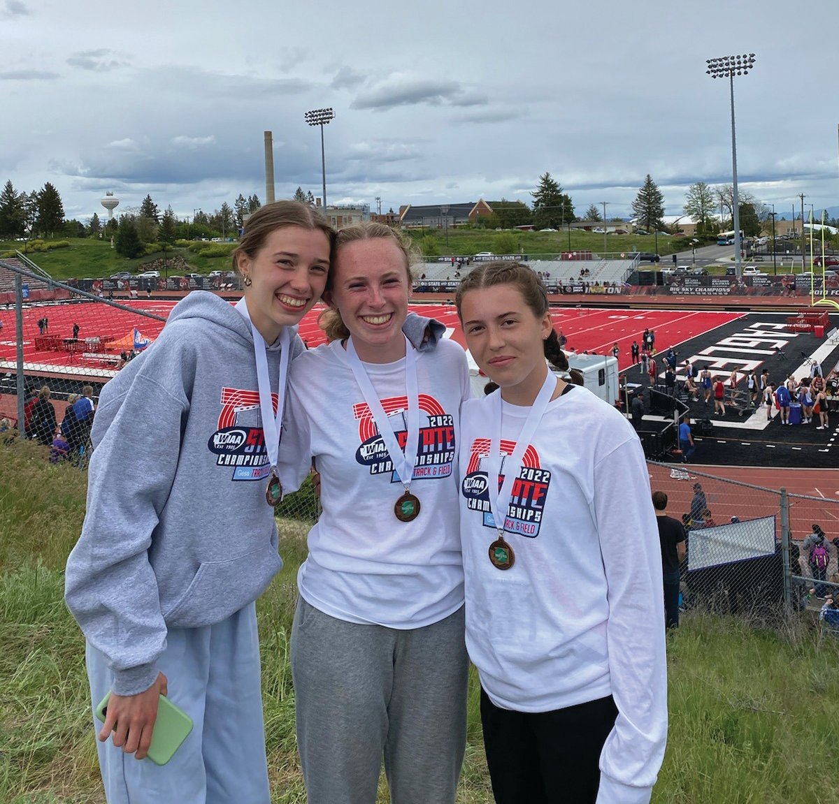 Aliyah Yearian, Camryn Hines, and Lia Poore pose together at the WIAA State Championship track meet in Cheney.